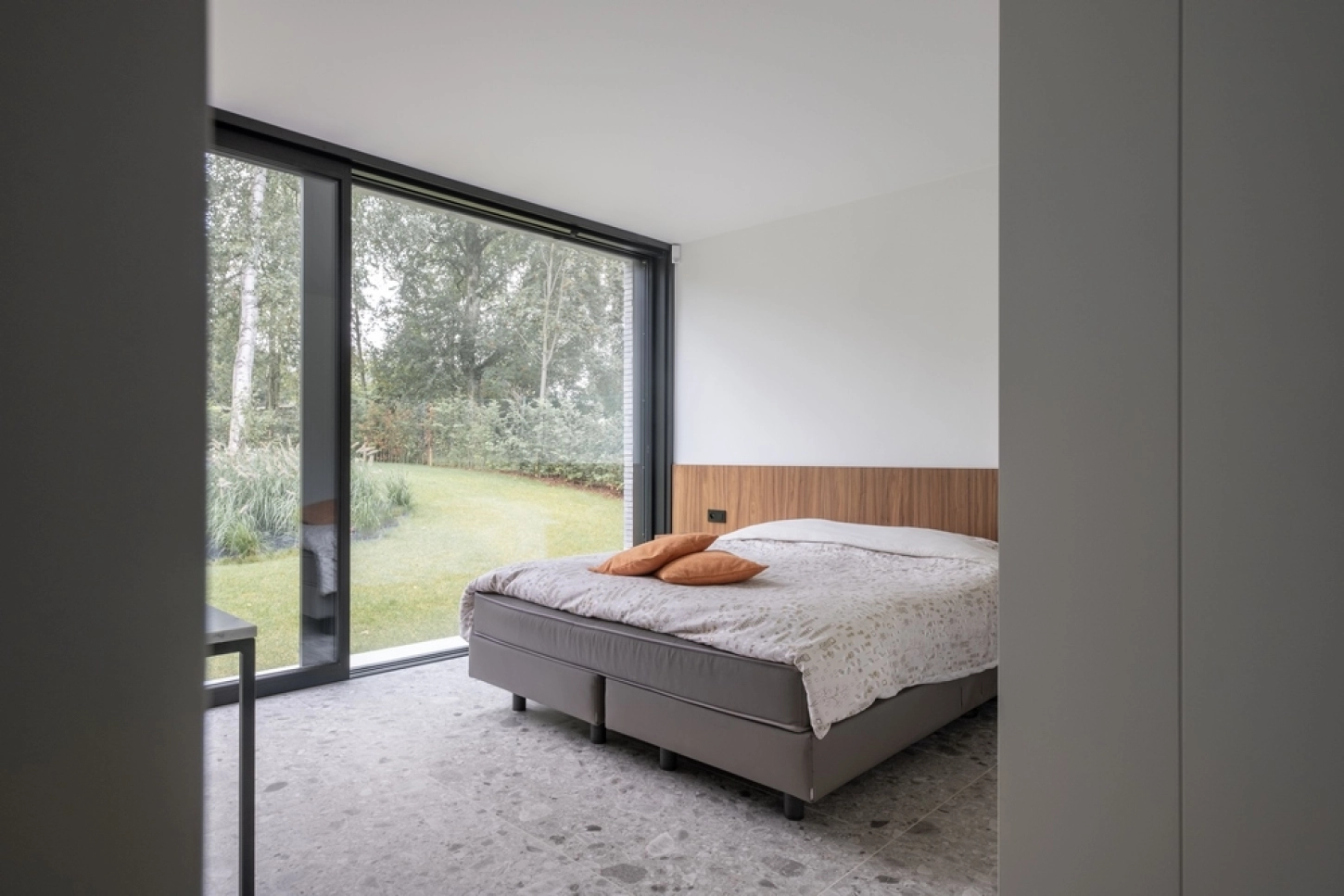 Lit avec tÃªte de lit en bois dans une chambre rustique.